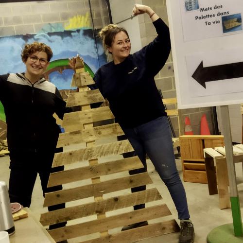 Deux participantes à l'atelier présentent leur sapin de Noël en palettes de bois