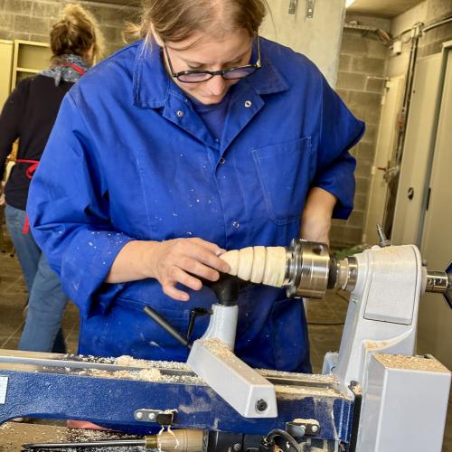 Une femme en train d'utiliser un tour à bois