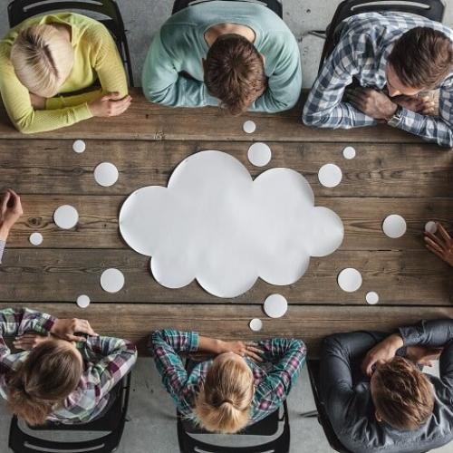 Vu d'en haut, un groupe de personne autour d'une table. Sur cette table est représenté un nuage.