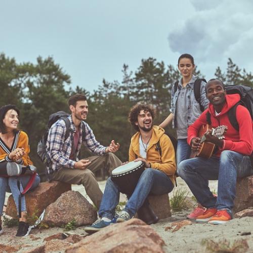 Un groupe de musicien·nes (djembés, percussions, guitare) sur la plage