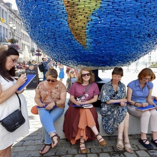 Un groupe de participantes en train d'écrire sur la place de Mons