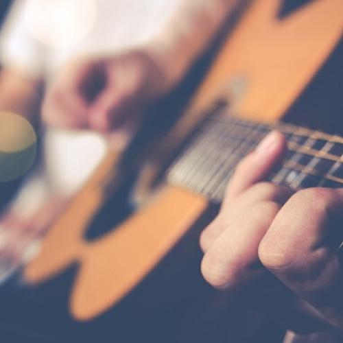Un gros plan sur une personne en train de jouer de la guitare