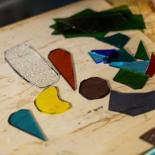 Une mosaïque avec des morceaux de verre colorés et taillés dans différentes formes